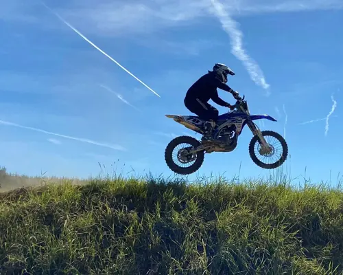 Motocross Motorrad beim Springen mit blauen Himmel